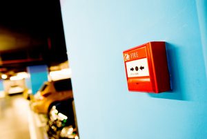 Fire alarm button on blue wall.